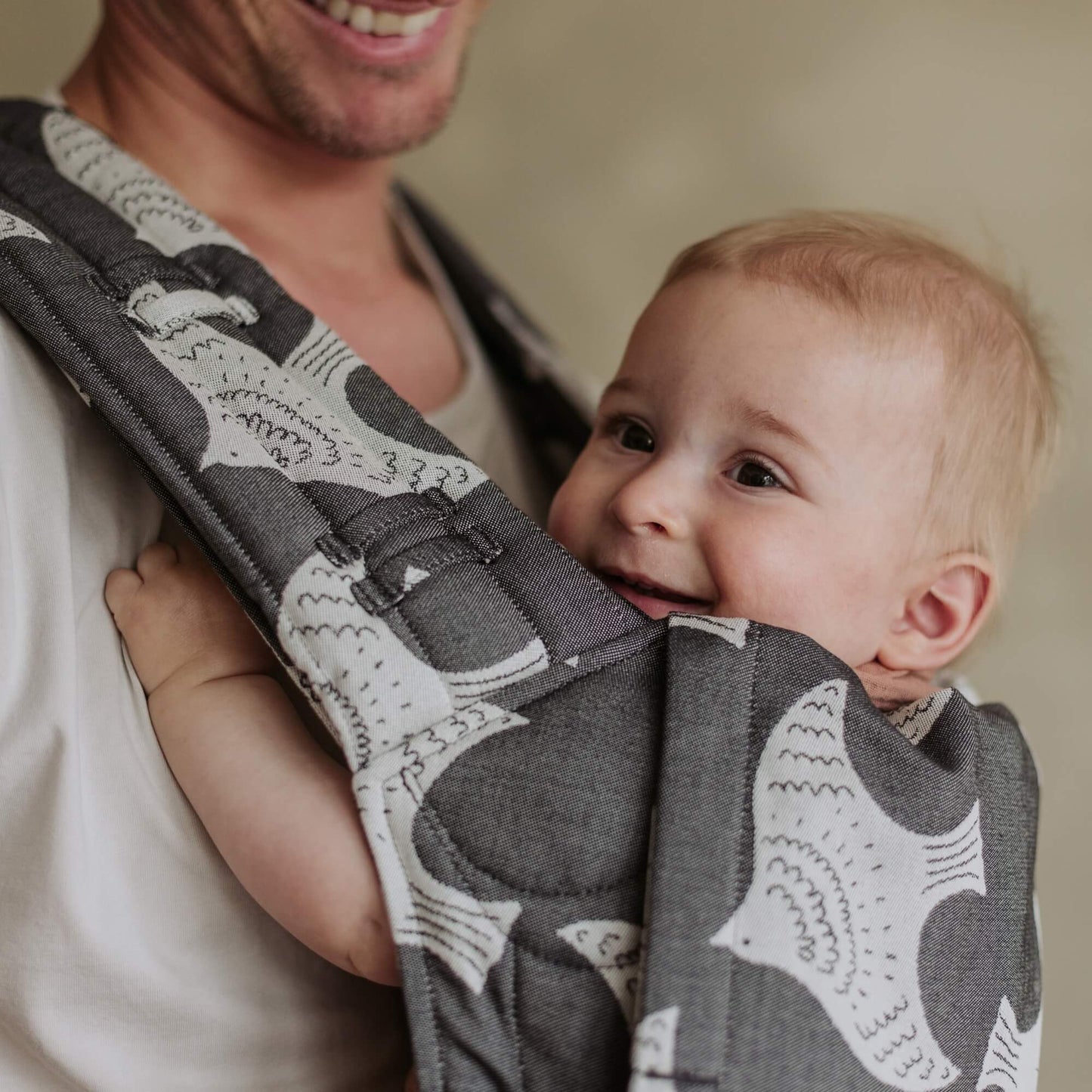 Ein Baby wird getragen in FlyClick Halbschnallen Babytrage Design Birds black ecru
