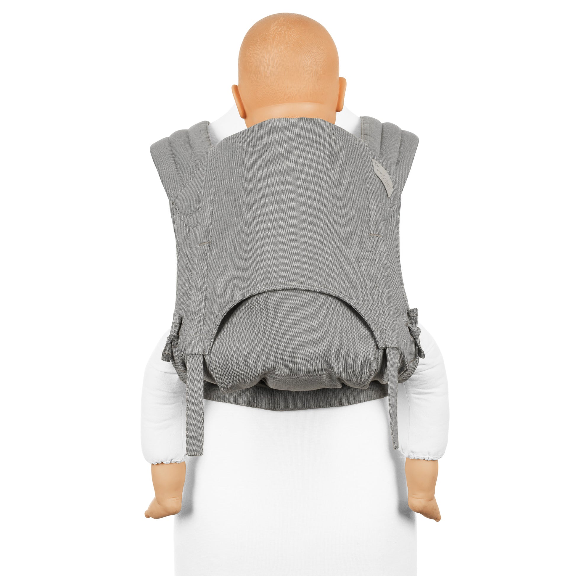 A toddler is carried in Fly Tai Mei Tai  Sling baby carrier Design Chevron  light gray