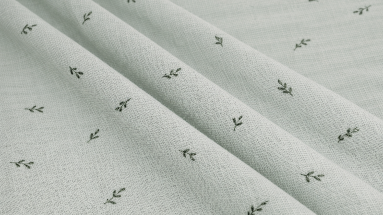 Close-up of light green fabric with small dark green leaf patterns